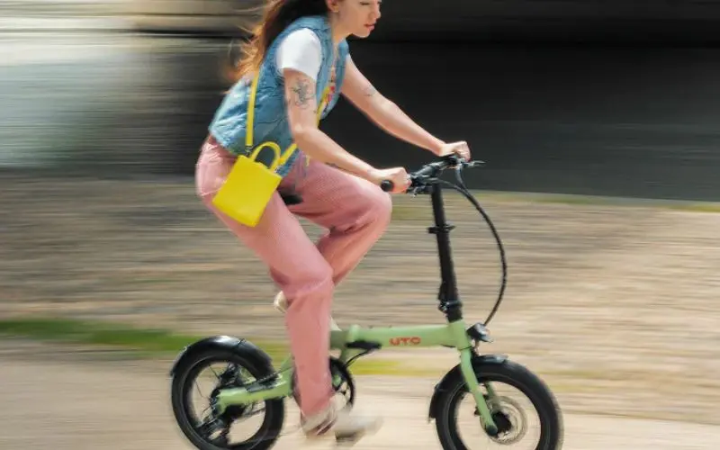 femme roulant sur un velo pliant en ville
